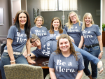 Trust department employees wearing Be a Hero shirts while smiling.